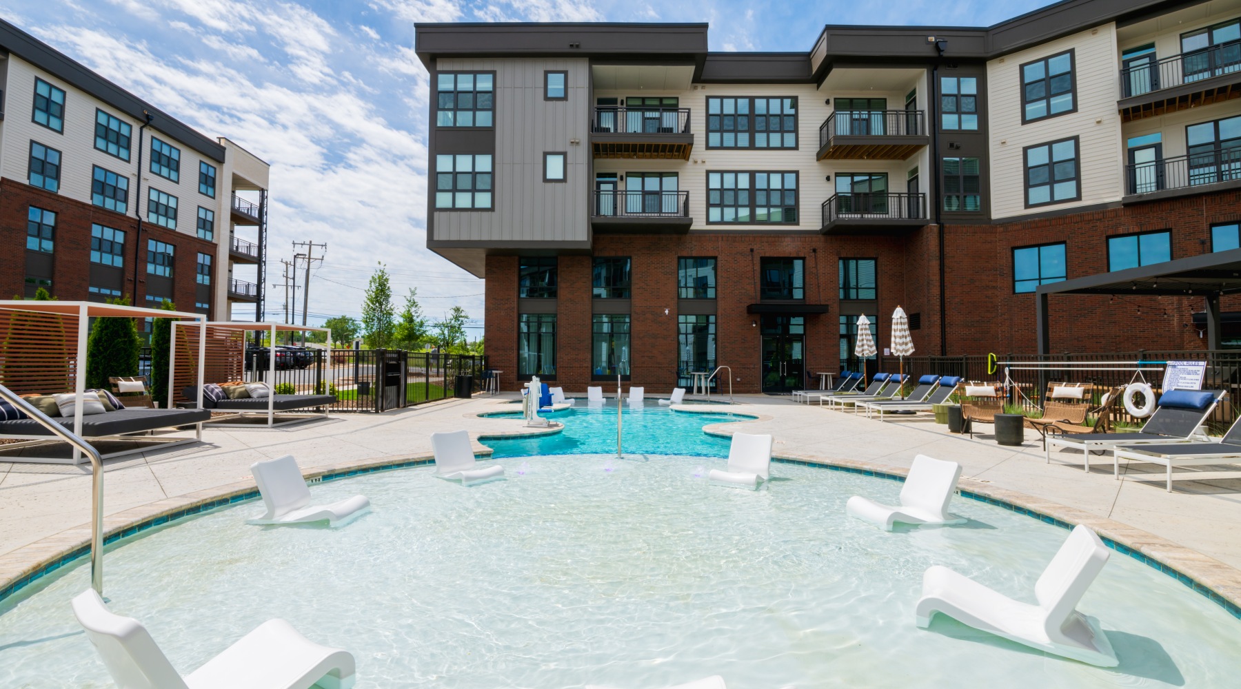 The pool area at 704 at the Quarter Apartments and Townhomes in Charlotte, NC, featuring lounge chairs and umbrellas. The pool area at 704 at the Quarter Apartments and Townhomes in Charlotte, NC, featuring lounge chairs and umbrellas.